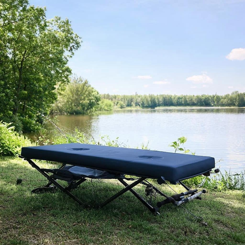 Carp fishing bedchair with thick mattress on lakeside